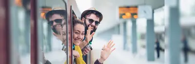 Young couple waving from a train window.