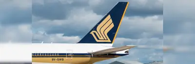 Tail of a Singapore Airlines plane against a cloudy sky backdrop