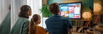 A family of three watching television.