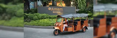 A photo of a tuk-tuk outside of Amari Bangkok sign