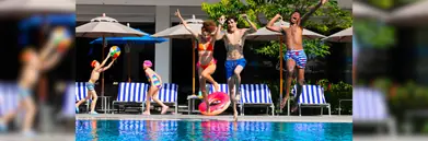 A woman and two men jump into an OZO pool