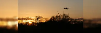An aircraft flying into the sunset