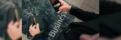 Phone and passport with suitcase above floor reading 'business'
