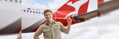 Robert Irwin pointing to a Qantas plane