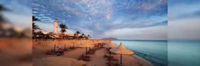Red Sea beach at dusk with sun loungers and umbrellas