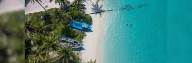 Birds-eye view of Maldives beach with boat and turquoise water