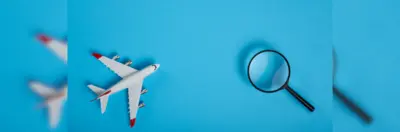 Graphic of a model aeroplane next to a magnifying glass.
