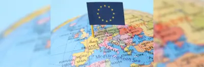 A globe featuring a European flag sticking out of northern France.