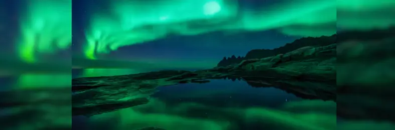 The Northern Lights in full flow over a lake.