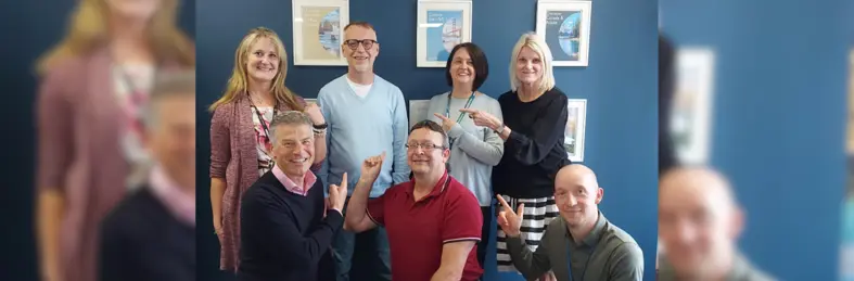 The Prestige Travel team pointing at new hire Dave Watson.