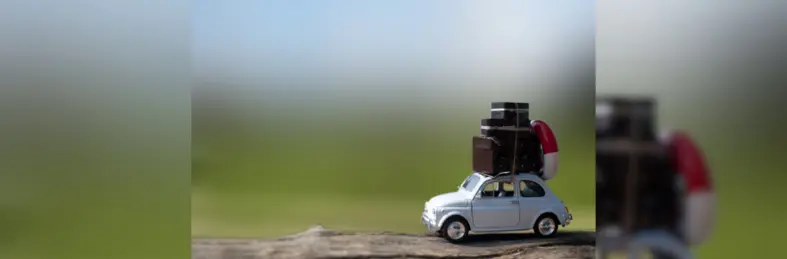 A model car with luggage and a life ring attached to its roof.