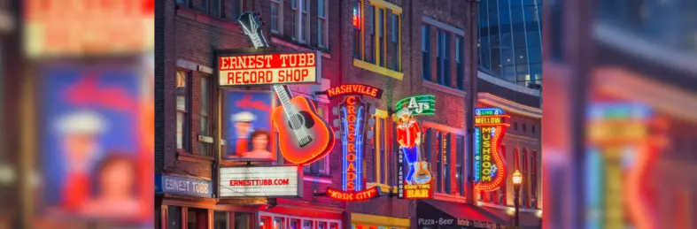 Illuminated neon signs along Lower Broadway, Nashville at night.