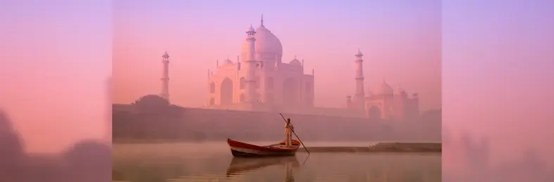 Image of a man in a boat in front of the Taj Mahal 