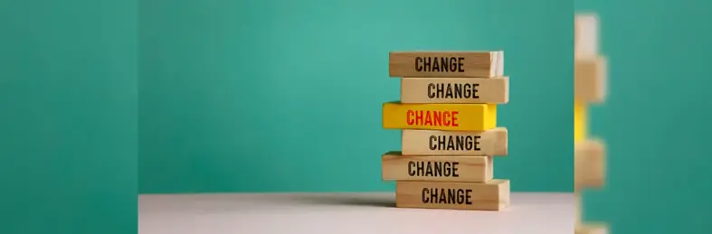 Six wooden blocks, five of which are labelled 'Change' with one yellow one in the middle labelled 'Chance'.