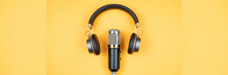 A podcast microphone and headphones over a warm yellow background