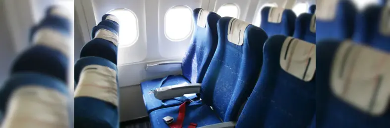 Unbranded airplane seats with blue fabric and white headrests.