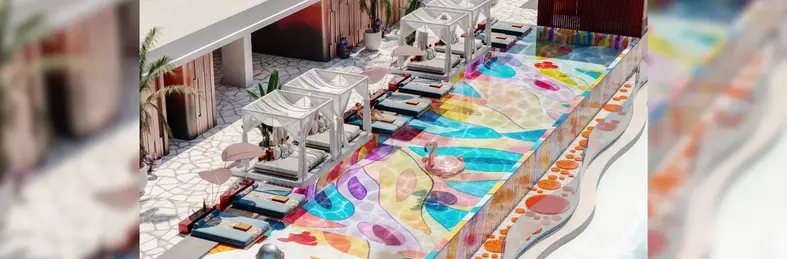 Image of the brightly-coloured pool and sunbeds at the hotel