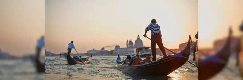 Image of people on a gondola rowing into the sunset