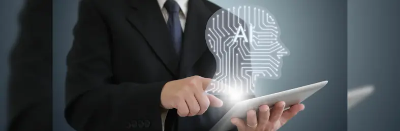 A person in a suit using a tablet computer, overlaid with a graphic of a side profile with 'AI' written inside. 