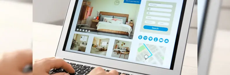 A person booking a hotel stay on a laptop.