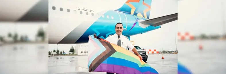 Image of a Air Transat plane with rainbow features and a pilot holding an LGBTQ+ flag 