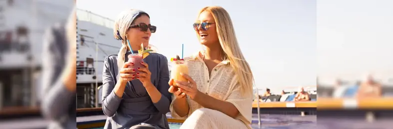 Two ladies drinking cocktails on the deck of a Celestyal ship
