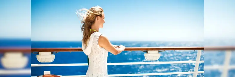 A person in a white hooded vest stood on the balcony of a cruise ship. 