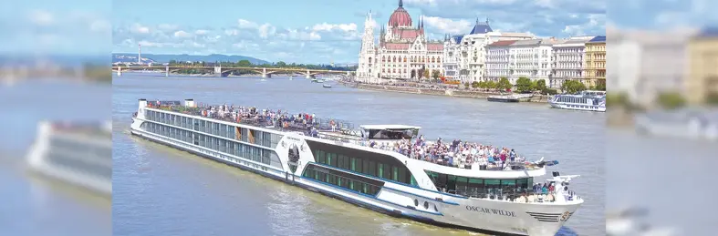 Riviera Travel's Oliver Wilde cruise ship sailing past the Hungarian Parliament Building in Budapest, Hungary.