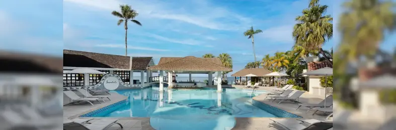 Image of a Sandals Resort pool area with sun loungers and cabanas