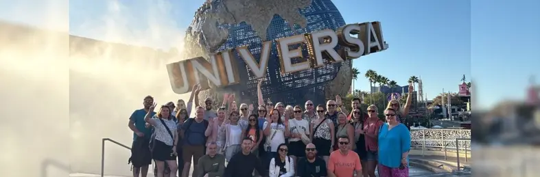 Travel Counsellors World Cup winners celebrating in front of the globe at Universal Orlando Resort.