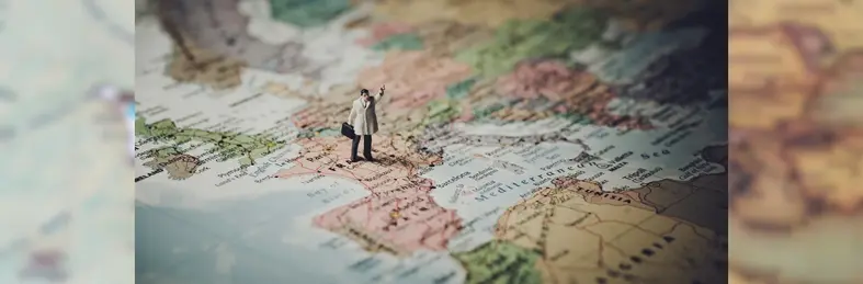 A small figurine of a person placed on France on a map of Europe. 