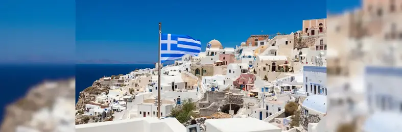 Image of a Greece flag against a metropolitan coastline