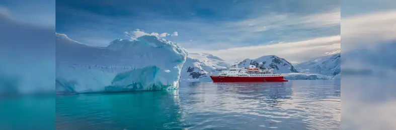 A red expedition ship sailing in Antarctica. 