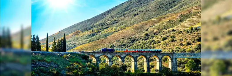 A steam train traveling through the Douro Valley in Portugal