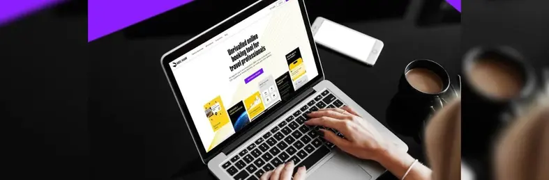 A travel agent navigating the RateHawk website on an Apple laptop.