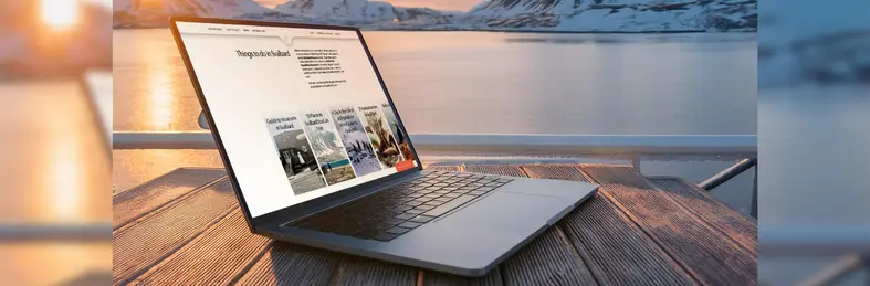 An Apple Macbook open on the new Secret Atlas website on the deck of an expedition cruise.