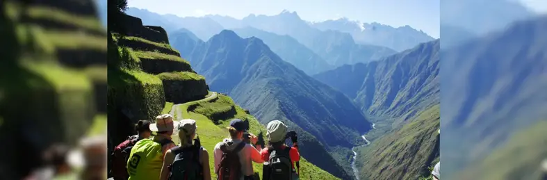 Tourists taking pictures of a a vast mountain landscape