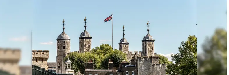 The four turrets of the Tower of London with the Union Flag waving.