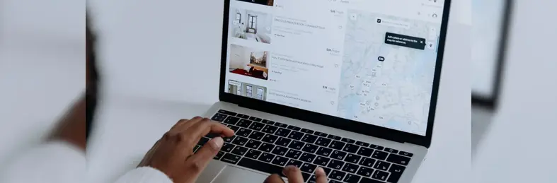 A black person navigating a hotel booking platform on their laptop.