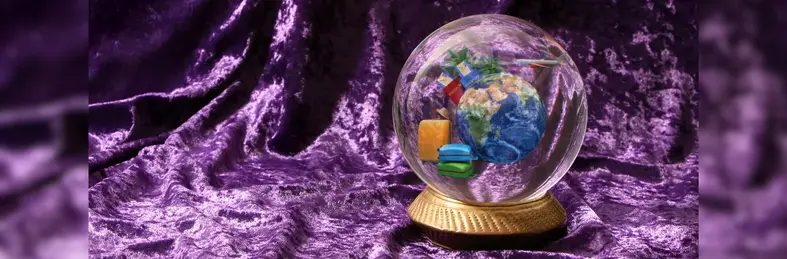 A crystal ball on a table lined with purple velvet: inside the crystal ball is a globe, some suitcases, and an aeroplane.