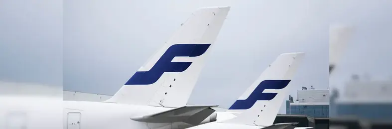 Two aircraft tails with the Finnair logo against a grey skies backdrop