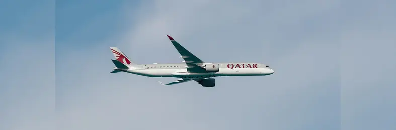 A Qatar Airways plane flying through the sky