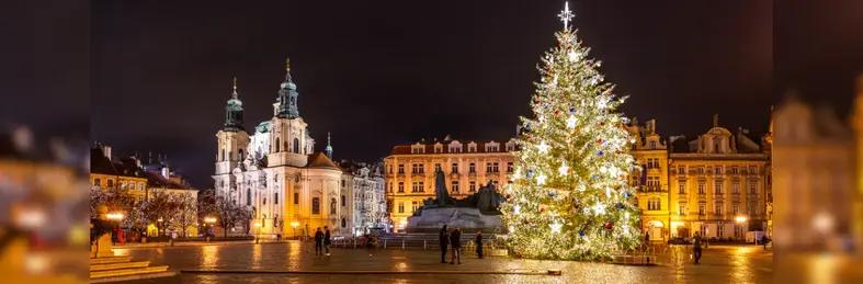 Prague city centre at Christmas time with lights and a Christmas tree in the square