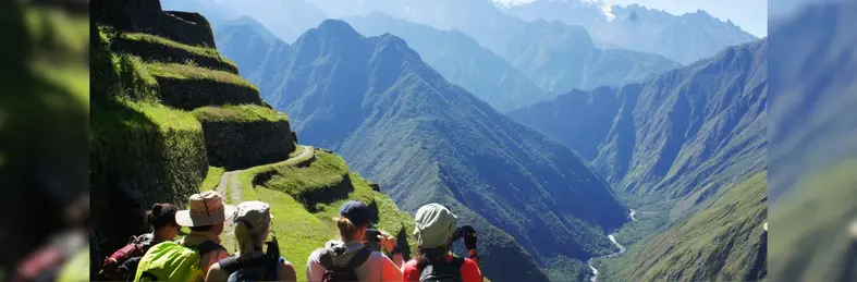A group of trekkers on the Inca Trail, looking out over the mountainous landscape of the Peruvian Andes