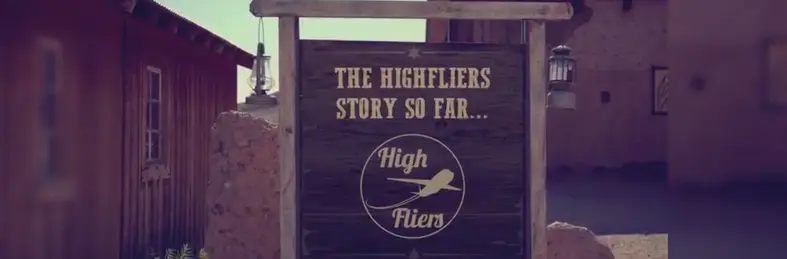 A message board in a Western-style town with 'The Highfliers Story So Far...' written on it.