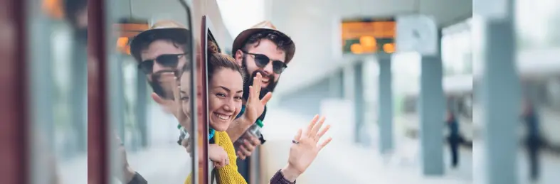 Young couple waving from a train window.