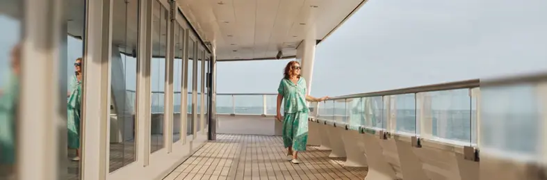 Jane McDonald walking along the deck of a cruise ship.