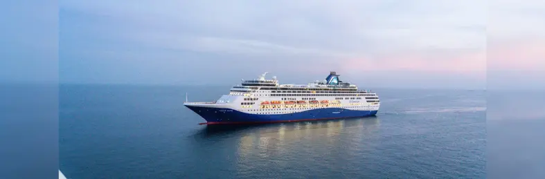 Celestyal Journey at sea against a purple sunset.