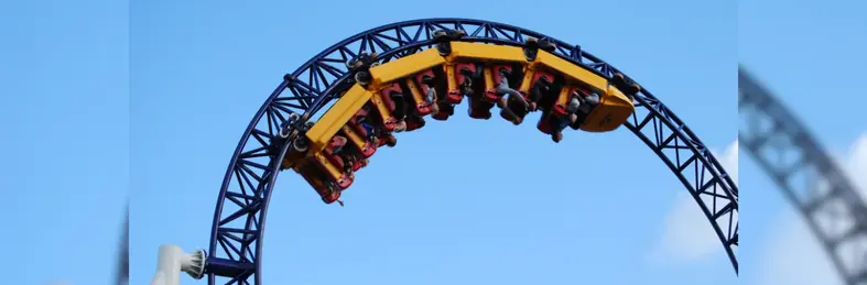 A yellow rollercoaster car on a black track.