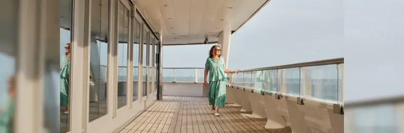 UK personality Jane McDonald walking along the deck of Scenic Eclipse, looking out to sea 